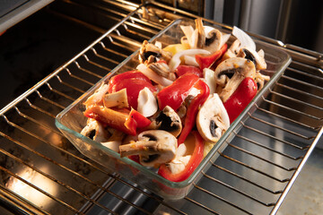 Uncooked vegetables and mushrooms dish in the oven
