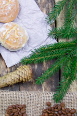 Cakes on a wooden background. Coffee beens on a linen fabric. Breakfast coffee. Fir branch and cones. Vertical view