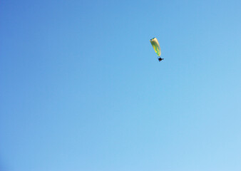 skydiver soars high in the clear sky
