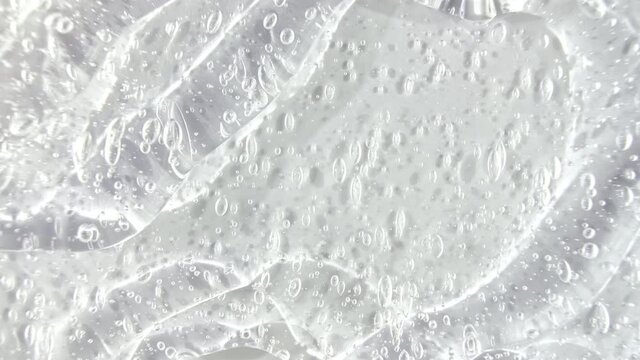 Transparent liquid gel cream with micro Bubbles as it slowly slides down. Macro Shot. High quality 4k footage