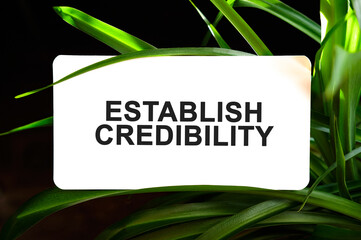 ESTABLISH CREDIBILITY text on white surrounded by green leaves
