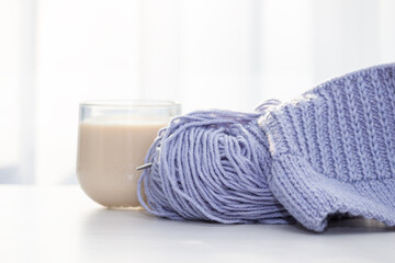 A peace of lilac knitting with knitting needles.Female hobby and leisure knitting concept.