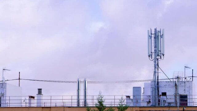 chimney fuming into the atmosphere next to a 5g antenna