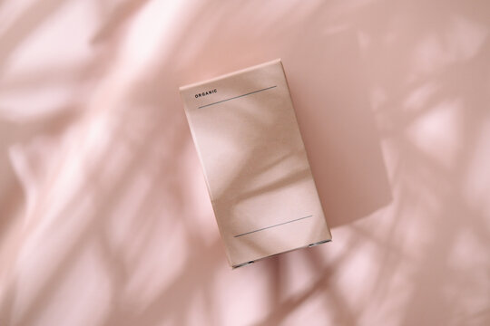 Minimalist beauty box on pastel pink in leaves shadows