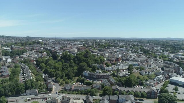 Aerial tracking forward over a city in bloom in Exeter, Devon