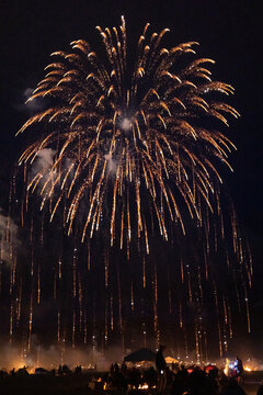 large fireworks display over a crowd of anonymous people