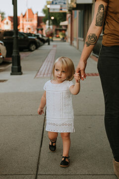 Young Girl Walking and Holding Mother's Hand