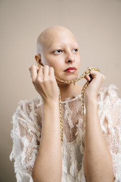 Fashionable bald woman looking at away