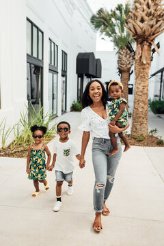 Mom And Kids In Matching Outfits Walking In Shopping Center