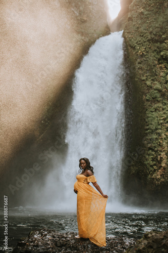 Beautiful, Black Pregnant Woman in front of Waterfall
