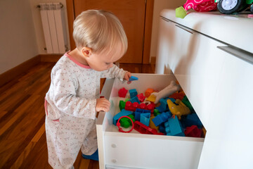 girl opening toy drawer