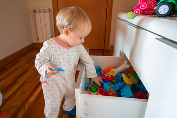 girl opening toy drawer