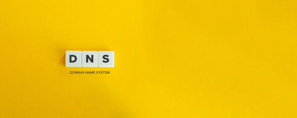 DNS (Domain Name System) banner and concept. Block letters on bright yellow orange background....