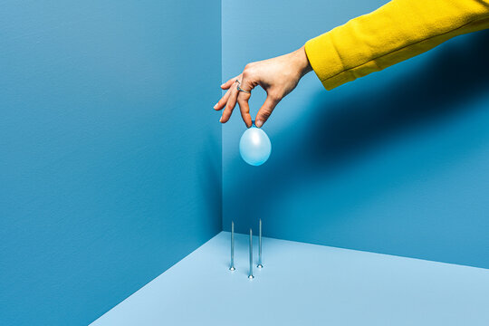 Crop model arranging balloons on blue backgroud