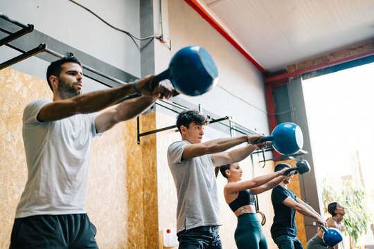 Young athletes exercising with kettlebells