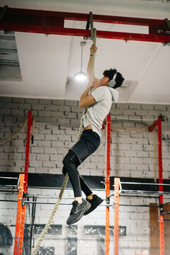 Sportsman climbing up a rope