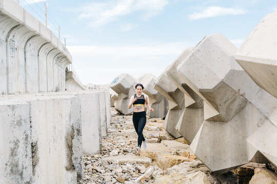 Young sportive woman runing next to ruined construction