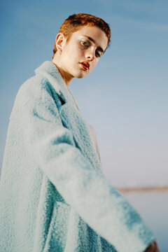 Concentrated young female model in coat in street