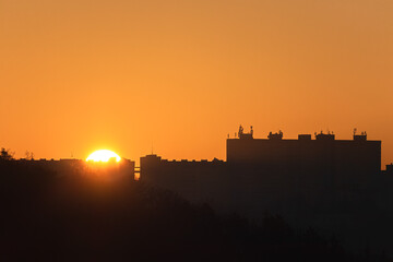 Sun rising from the buildings.