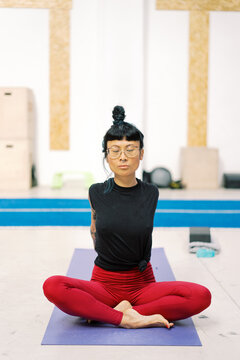 Female practicing sitting in sukhasana position