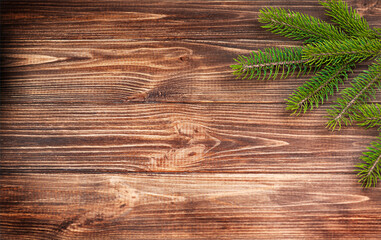 Christmas fir branch on a brown wooden background.