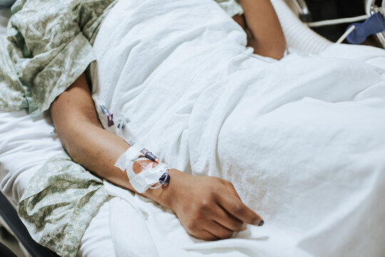 Woman's Arm with IV in Hospital Bed