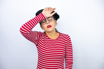 Young beautiful brunette woman wearing french beret and glasses over white background Touching forehead for illness and fever, flu and cold, virus sick