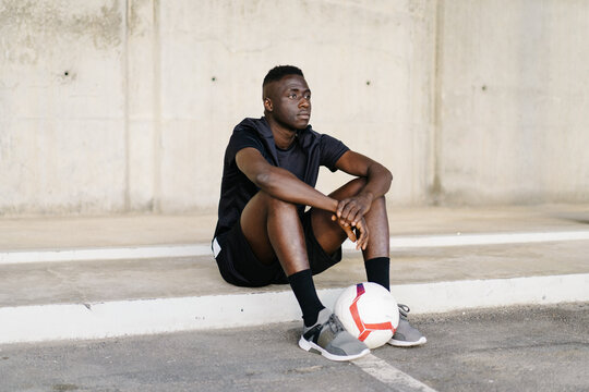 Sportsman with soccer ball looking at camera