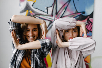 Cheerful girls making different figures by hands.