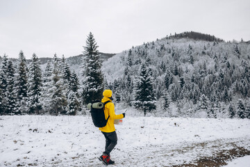 Climber holding map and going to peak of snowy mountain.