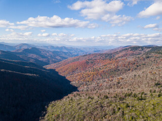 An Aerial view of the Blue Ridge Mountains of North Carolina during autumn with patches of colorful foliage.