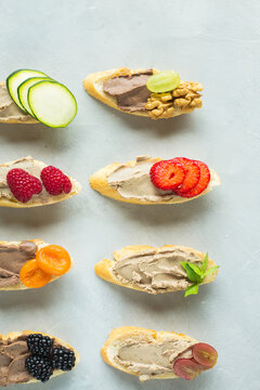 Colored bruschetta with pate, berries, dried fruits.