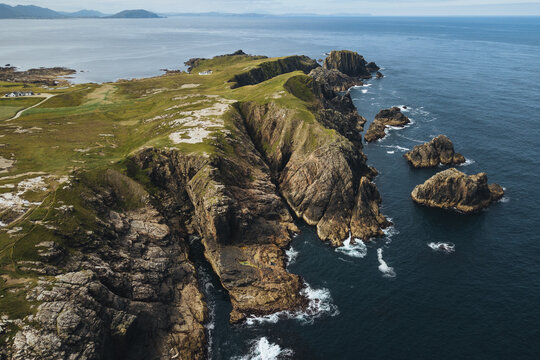 Aerial view of a peninsula with cliffs and rocks.