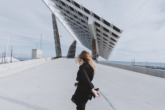 Fashionable woman walking through bridge.
