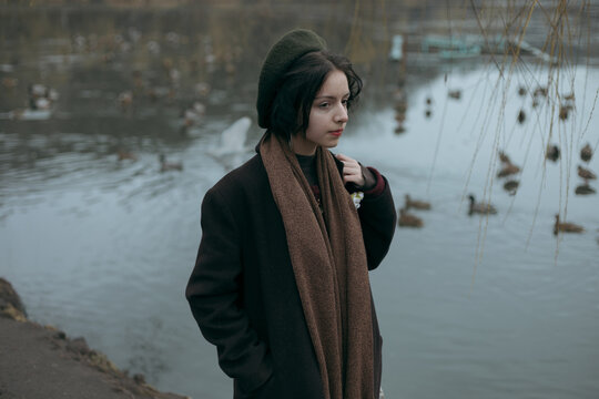 girl in a coat and take it. holds his hand in his pocket and looks away