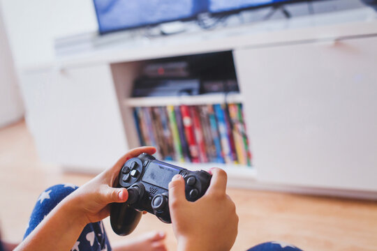 gaming, child teenager playing video game, close up of hands with joystick