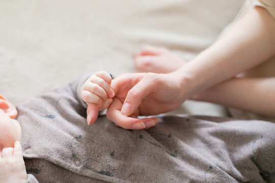 child holds mom by the finger