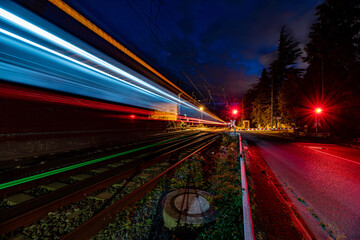 Fototapeta na wymiar Zug fährt durch Bahnübergang / Train passes railway crossing