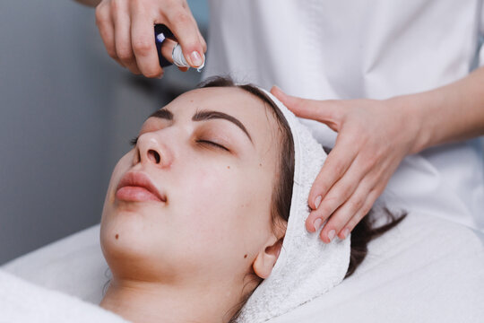 Doctor applying cleansing gel on human face.