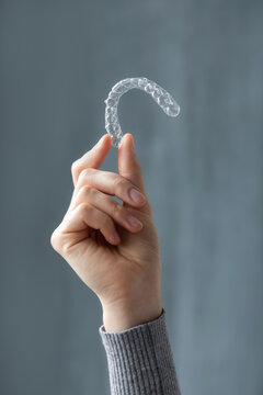 Hand holding orthodontics retainer