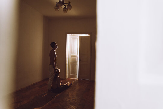 Silhouette of girl and boy standing near luminous door