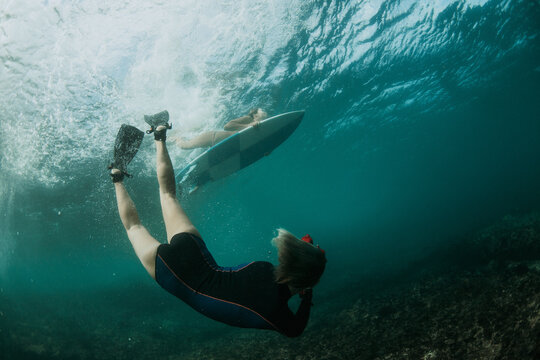 Girl photographer takes pictures of surfing underwater