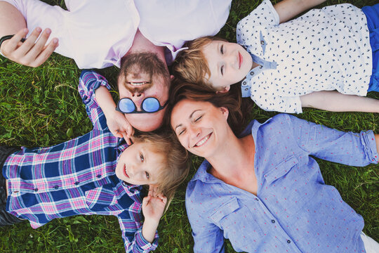 portrait of happy family lying on the grass in summer, view from above
