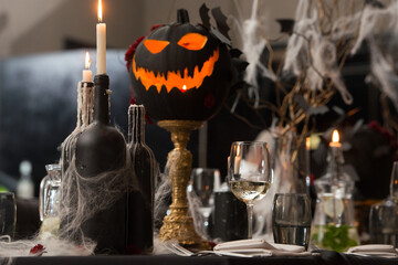 Table set for Halloween dinner. Served holiday table with candles and pumpkin