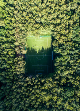 Aerial view of a soccer field in a dense forest