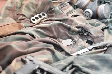 Stalker soldiers soviet gas mask lies with handgun and knife on green khaki camouflage jackets