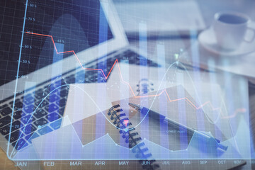Double exposure of financial chart drawing and desktop with coffee and items on table background....