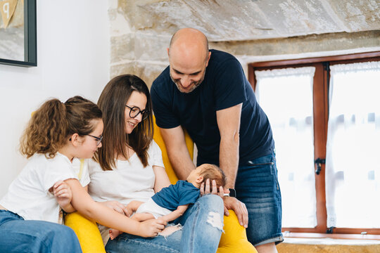 Happy Family With New Born Baby At Home