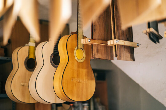 Guitars hanging in a line at workshop