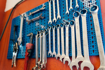 Close-up of work tools hanging on pegboard in workshop